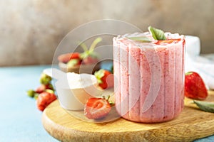 Fresh milk, strawberry drinks on wooden board on a stone background, protein shake with fresh berries. Copy space