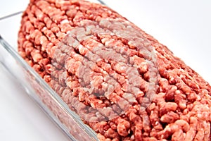 Fresh minced meat close-up in a glass dish plate.