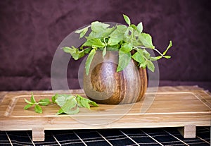 Fresh mint in a wooden brown bowl on the table