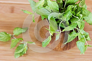 Fresh mint in a wooden brown bowl on the table