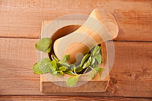 Fresh mint, wooden mortar, pestle on the wooden table