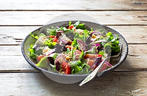 Fresh mix green leaves, tomatoes, soft cheese and walnuts salad