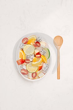 Fresh mixed fruit salad falling into a bowl of salad