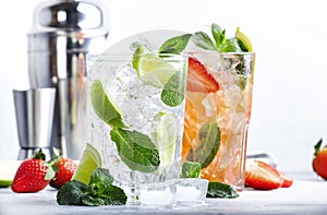 Fresh Mojito cocktail set with lime, mint, strawberry and ice in glass on gray background. Summer cold alcoholic non-alcoholic