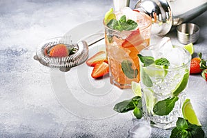 Fresh Mojito cocktail set with lime, mint, strawberry and ice in glass on gray background. Summer cold alcoholic non-alcoholic