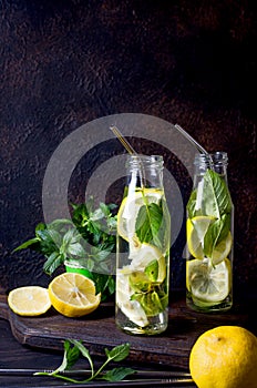 Fresh mojito drinks in bottles and ingredients - lemon and mint photo