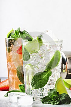 Fresh Mojito mocktail set with lime, mint, strawberry and ice in glass on gray background. Cold alcoholic or non-alcoholic drinks