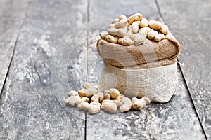 Fresh monkeynut in sack bag on wooden background
