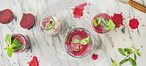 Fresh morning beetroot smoothie or juice in glasses, marble background