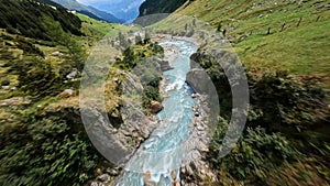 Fresh mountain river creek, flying over with a fpv drone. Adventure hiking forest and green grassland valley. Idylic