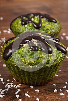 Fresh muffins with spinach, desiccated coconut and chocolate glaze, delicious healthy dessert