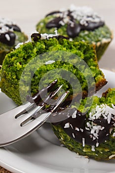 Fresh muffins with spinach, desiccated coconut and chocolate glaze, delicious healthy dessert