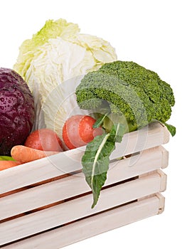 Fresh multi-colored vegetables in wooden crate. Organic food. White background