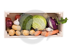 Fresh multi-colored vegetables in wooden crate. Organic food. White background