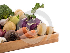 Fresh multi-colored vegetables in wooden crate. Organic food. White background