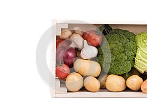 Fresh multi-colored vegetables in wooden crate. Organic food. White background