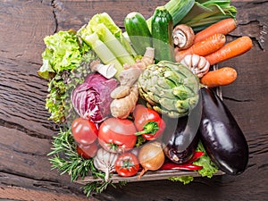 Fresh multi-colored vegetables in wooden crate. Top view.