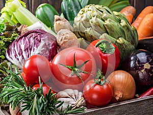 Fresh multi-colored vegetables in wooden crate. Top view.