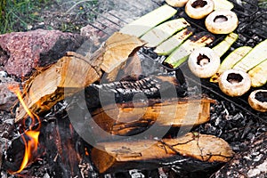 Fresh mushrooms and zucchini grilling on an outdoor barbecue