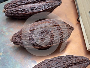 Fresh, natural, cocoa and cacao bean hulls sitting on a metal ta