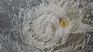 Fresh natural egg falls into flour heap. Preparation of homemade dough. Slow motion, Full HD video, 240fps, 1080p. Top