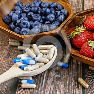 Fresh natural fruits vs pills. Natural vitamin in fruits vs synthetic vitamin in pills. Choice between natural and synthetic way