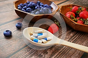 Fresh natural fruits vs pills. Natural vitamin in fruits vs synthetic vitamin in pills. Choice between natural and synthetic way