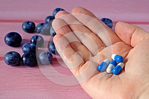 Fresh natural fruits vs pills. Natural vitamin in fruits vs synthetic vitamin in pills. Choice between natural and synthetic way