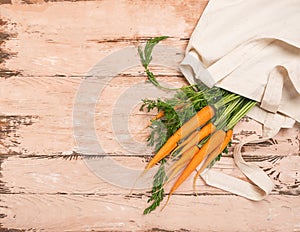 Fresh natural organic carrot bag made of cotton wooden rustic background. Natural organic products. Ecology concept.