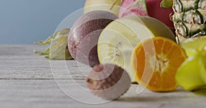 Fresh natural organic exotic fruits on a wooden gray background. Concept of vegetarian diet eating. Panoramic motion, 4K