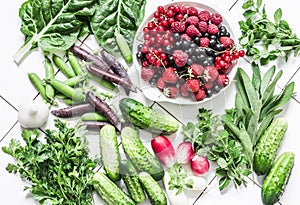 Fresh natural organic products - vegetables, herbs, berries on a light background, top view. Flat lay