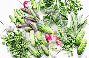 Fresh natural organic products - vegetables, herbs on a light background, top view. Flat lay. Cucumbers, peas, cilantro, mint,