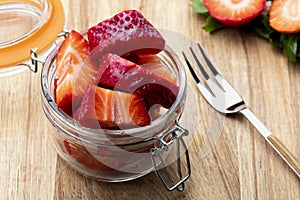 Fresh and natural strawberries big strawberries in a glass jar and a tendor. Foreground