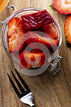 Fresh and natural strawberries big strawberries in a glass jar and a tendor. Foreground