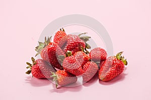 Fresh natural strawberries in white bowl on soft pink background