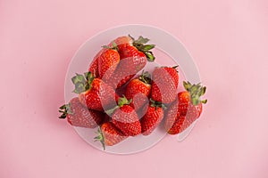 Fresh natural strawberries in white bowl on soft pink background