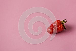 Fresh natural strawberries in white bowl on soft pink background with copy space for your text