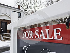 Fresh new sign for sale in front of detached house in residential area.