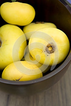 Fresh nutmeg in wooden bowl