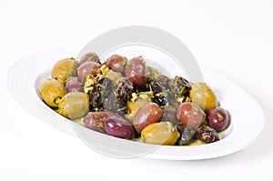 Fresh olives and prunes sauce in a white bowl.