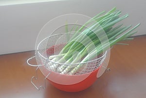 Fresh onion in a red plastic bowl