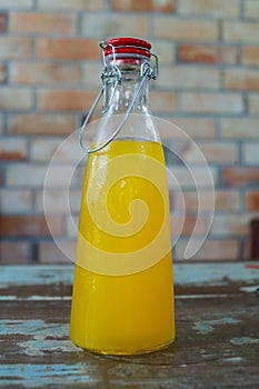 Fresh orance juice inside the bottle on wall loft style backgro