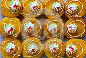 Fresh orange cake topped with sugar, colorful cream and strawberry jam in vintage Thai style