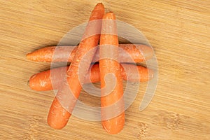 Fresh orange carrot on light wood