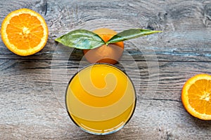 Fresh orange fruit with cut in half slice and green leaf glass of orange juice oisolated on wood background . Top view. Flat lay
