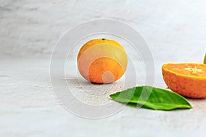 Fresh orange fruit cut in half on a white background
