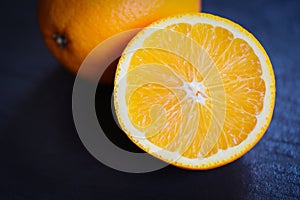 Fresh orange fruit slice half dark background