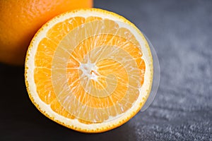 Fresh orange fruit slice half dark background