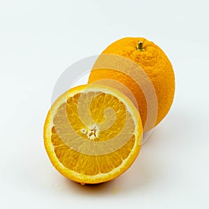 Fresh orange fruit with sliced and green leaves on white background