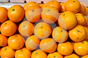 Fresh orange fruit symmetrically to attract buyers at market stall photo